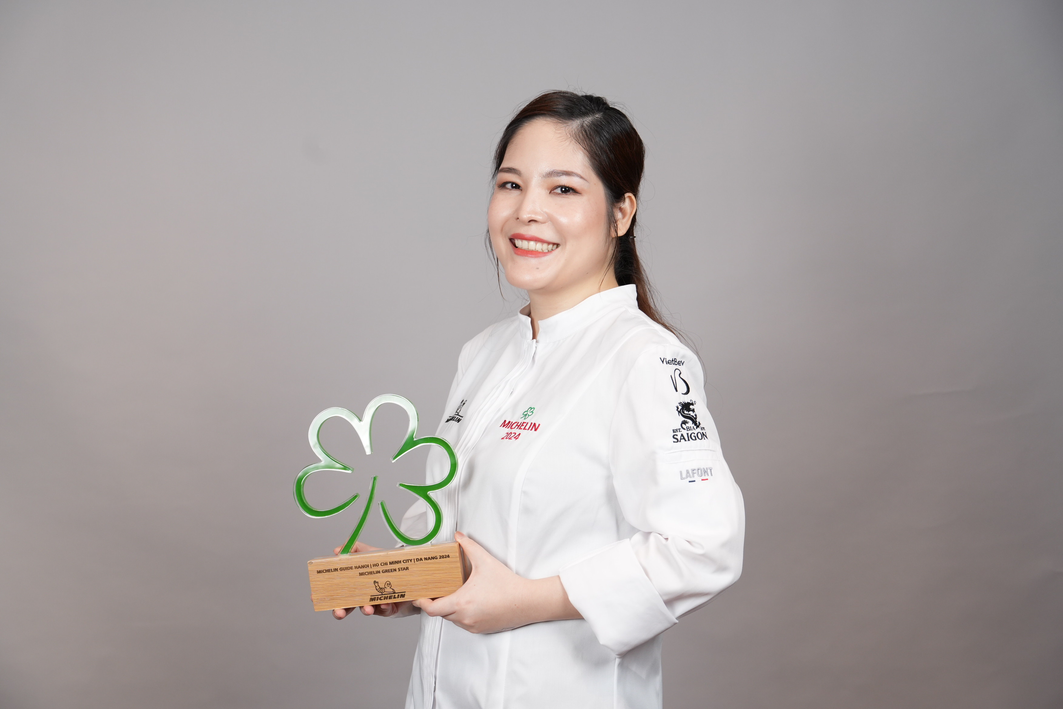 Summer Le, founder and executive chef of Nén Danang and Nén Light Saigon, poses for a photo with the green Michelin star awarded to Nén Danang in June 2024. Photo courtesy of Summer Le